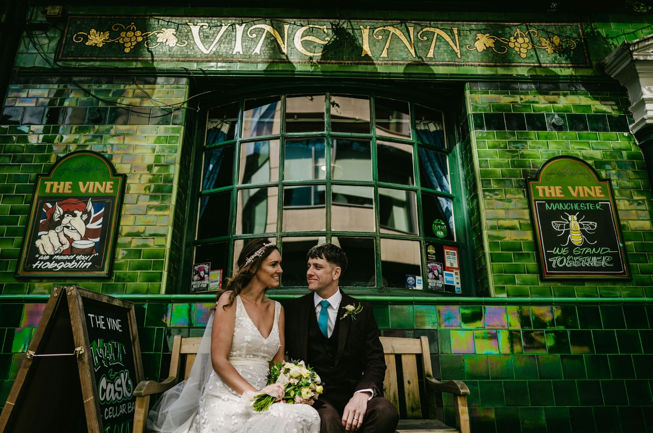 wedding couple on bench outside manchester pub