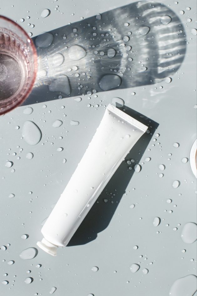 white tube on wet table with pink glass